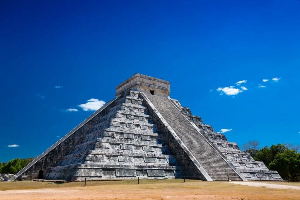 Pirámide de Kukulkán en Chichén Itzá, Yucatán, con su escalinata central bajo un cielo azul despejado.