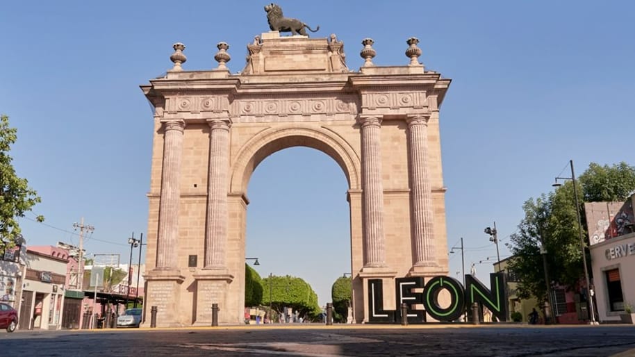 Arco de la Calzada de los Héroes en León, Guanajuato, con un león sobre la cima y las letras grandes de León en la base